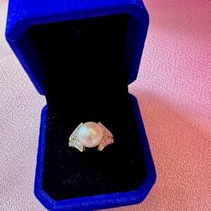 Lustrous Pearl in 10kt gold setting, surrounded br pave set diamonds.